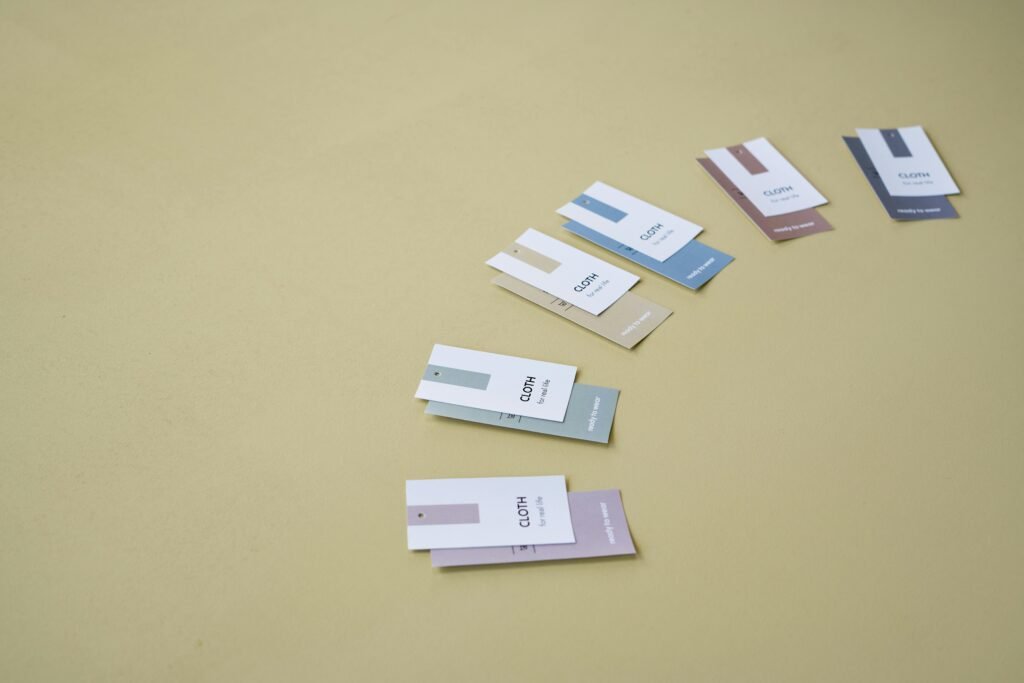 Multicolored clothing labels arranged on a beige background, featuring ample copy space.